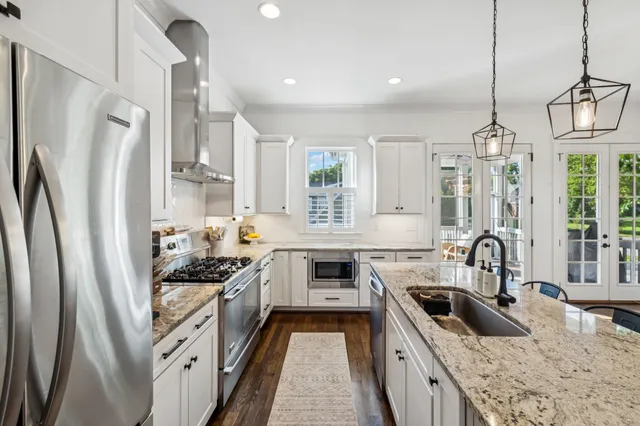 a kitchen with stainless steel appliances granite countertop a sink stove and refrigerator
