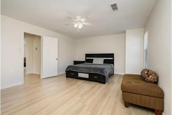 a bedroom with a bed and wooden floor
