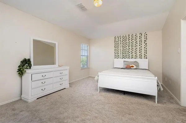 a bedroom with a bed and a dresser
