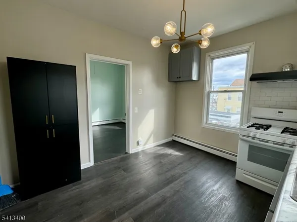 a view of an empty room with a kitchen and a window