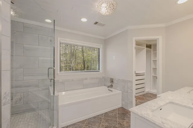 a spacious bathroom with a tub sink and shower