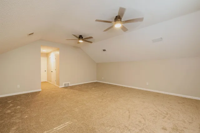 an empty room with a ceiling fan and a window