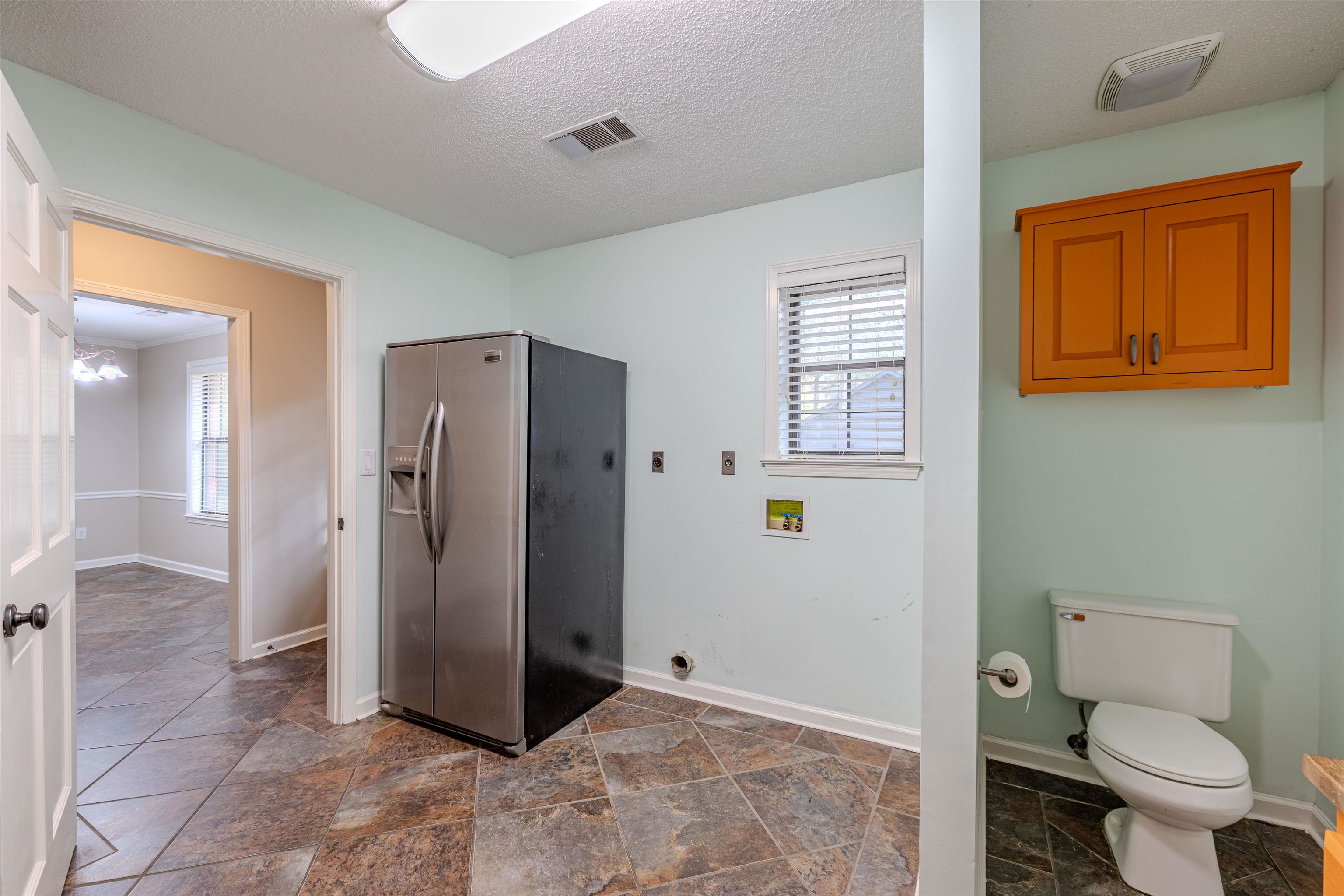 4808 Oak Road Bartlett, TN 38002 - Photo 20 of 35 Laundry room with half bath with a textured ceiling and stone tile floors