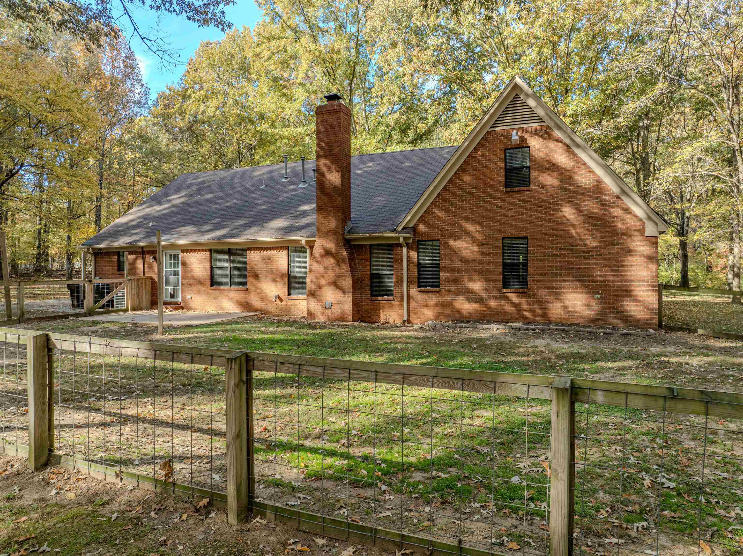 4808 Oak Road Bartlett, TN 38002 - Photo 3 of 35 View of back facade with a chimney, a fenced backyard, brick siding, and a shingled roof