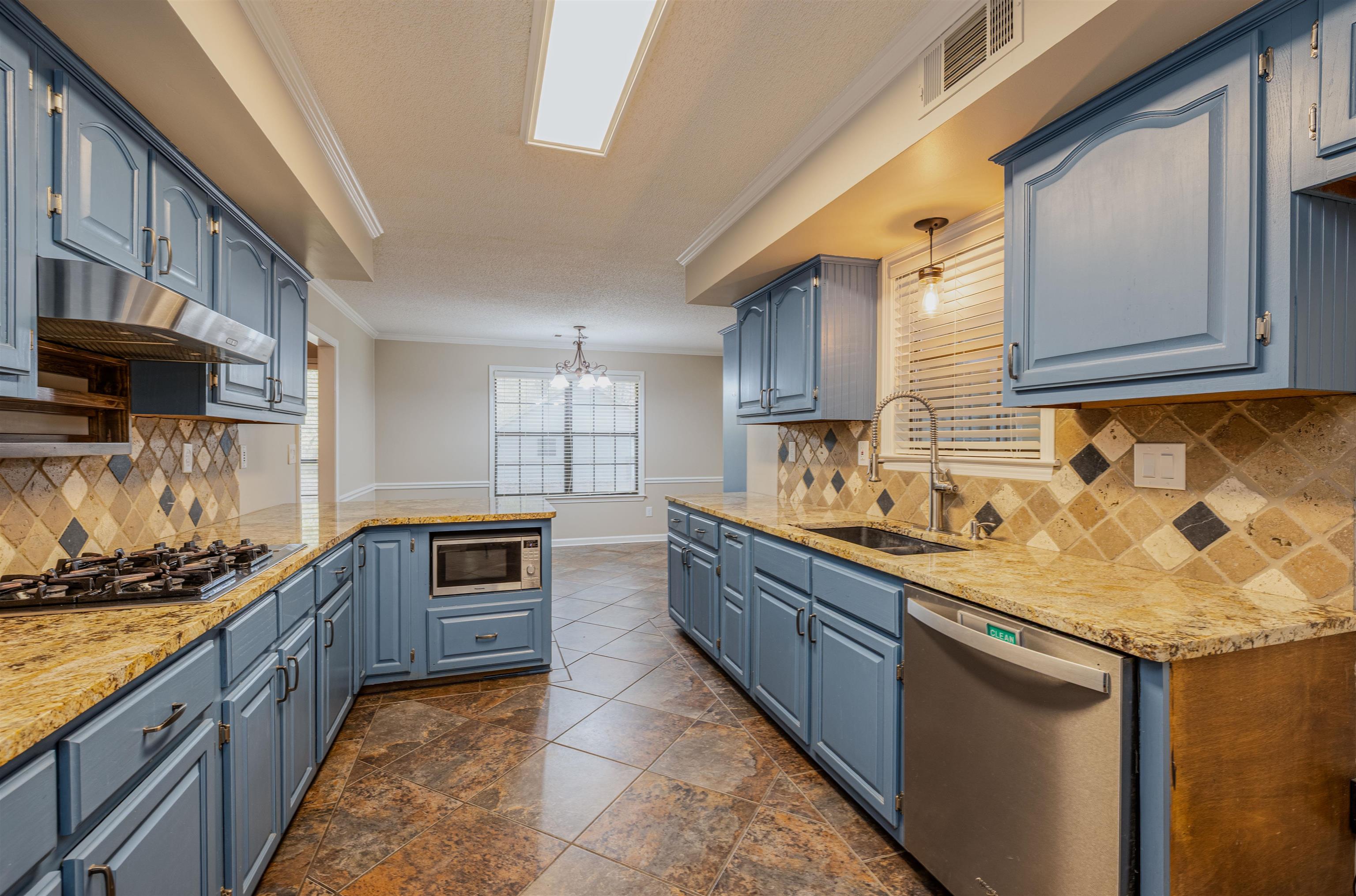 4808 Oak Road Bartlett, TN 38002 - Photo 8 of 35 Kitchen with decorative backsplash, crown molding, blue cabinetry, and stainless steel appliances