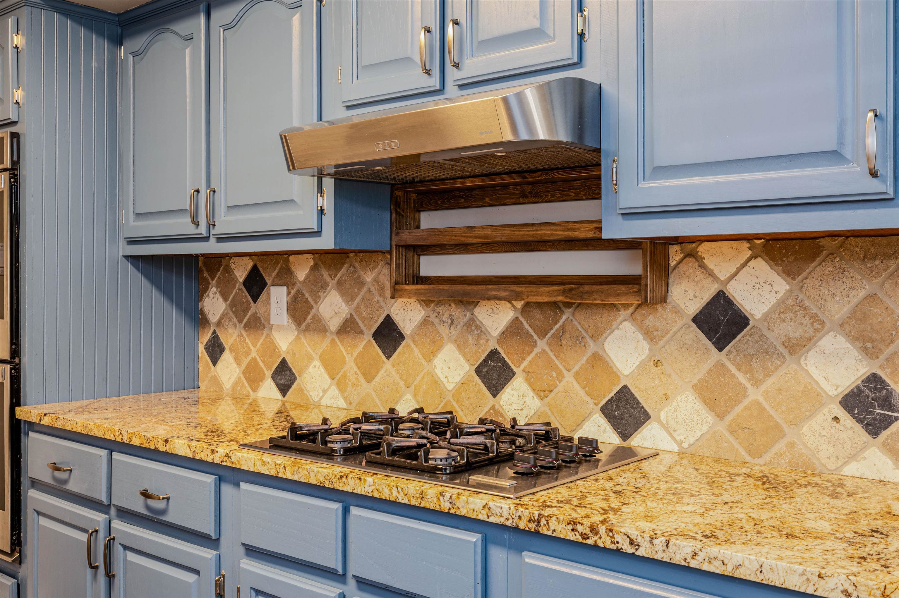 4808 Oak Road Bartlett, TN 38002 - Photo 9 of 35 Kitchen featuring decorative backsplash, blue cabinets, black gas cooktop, light stone countertops, and under cabinet range hood