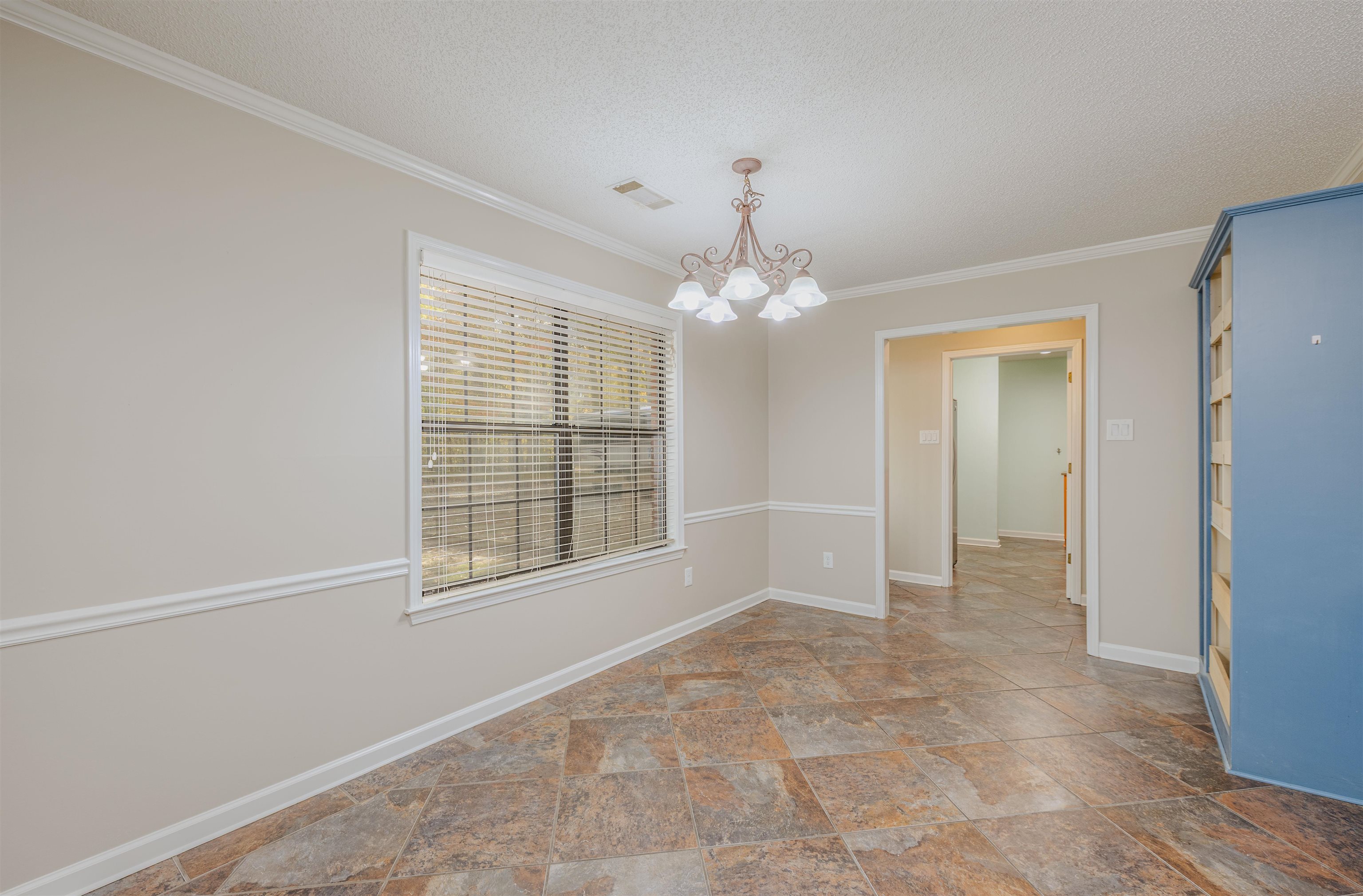 4808 Oak Road Bartlett, TN 38002 - Photo 10 of 35 Breakfast room featuring crown molding, a chandelier, light stone finish floors, and a textured ceiling