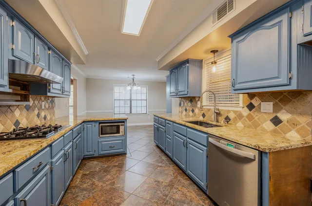a kitchen with stainless steel appliances granite countertop a sink stove and cabinets