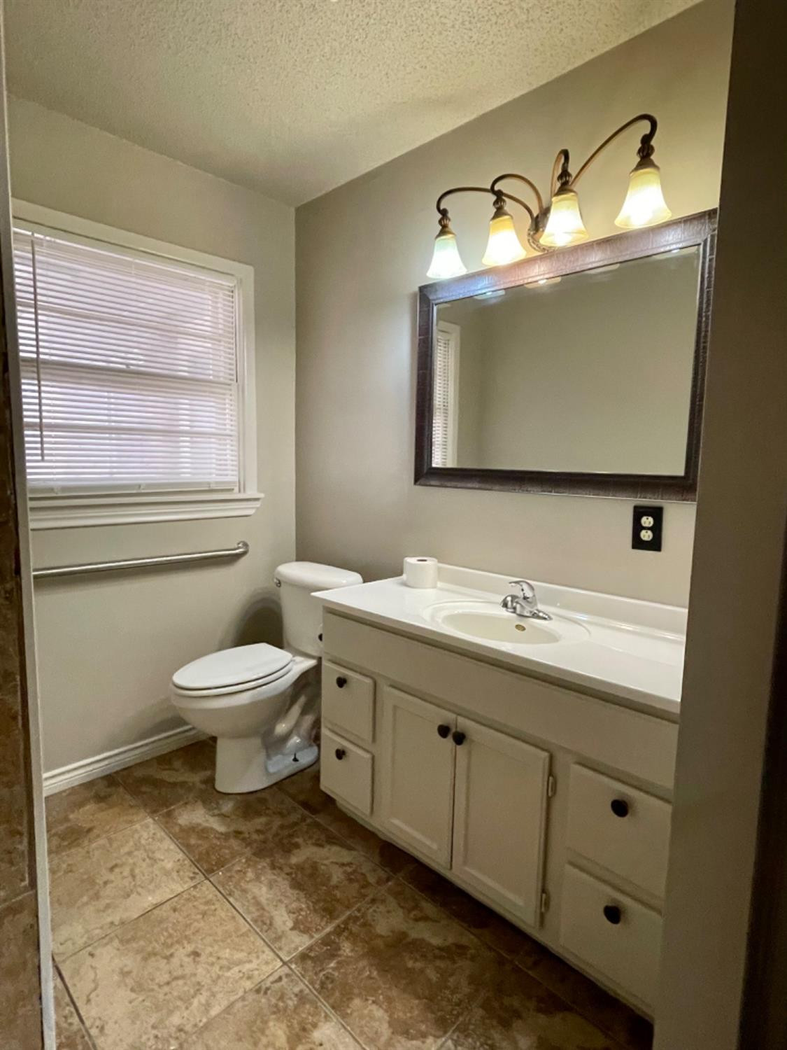 1201 Adrian Street Lubbock, TX 79403 - Photo 14 of 19 a bathroom with a toilet sink and mirror