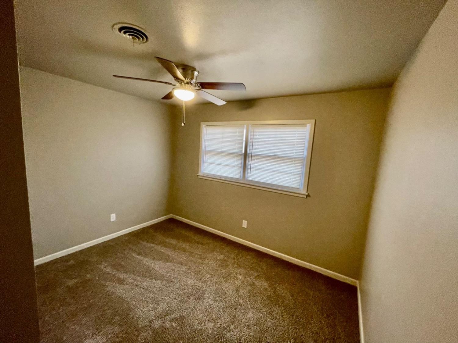 1201 Adrian Street Lubbock, TX 79403 - Photo 18 of 19 an empty room with a ceiling fan and a window