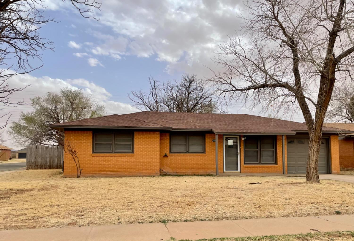 1201 Adrian Street Lubbock, TX 79403 - Photo 2 of 19 a front view of a house with a yard
