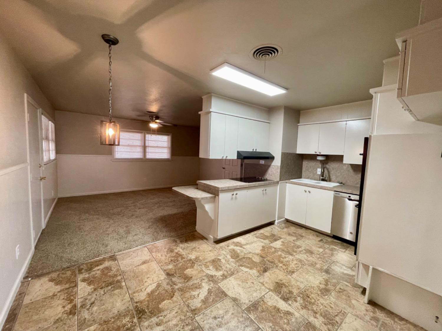 1201 Adrian Street Lubbock, TX 79403 - Photo 6 of 19 a large white kitchen with a stove a refrigerator and a sink