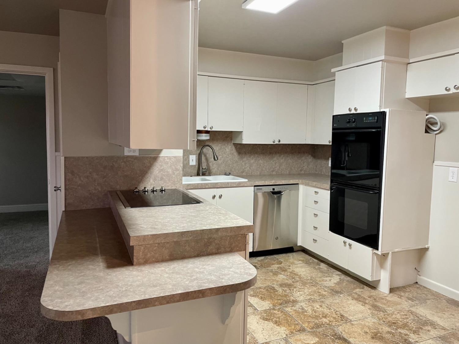 1201 Adrian Street Lubbock, TX 79403 - Photo 8 of 19 a kitchen with a stove a refrigerator and cabinets