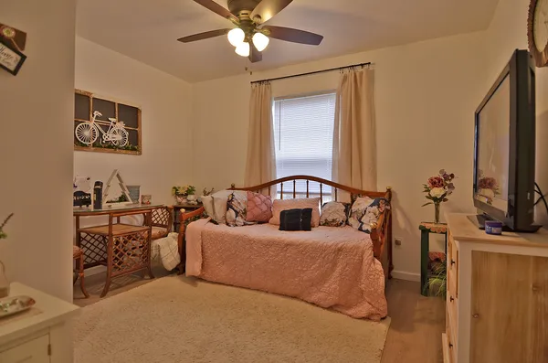 a bedroom with a large bed and a flat tv screen on dresser
