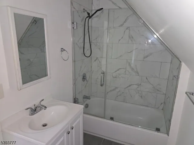 a bathroom with a sink mirror and shower