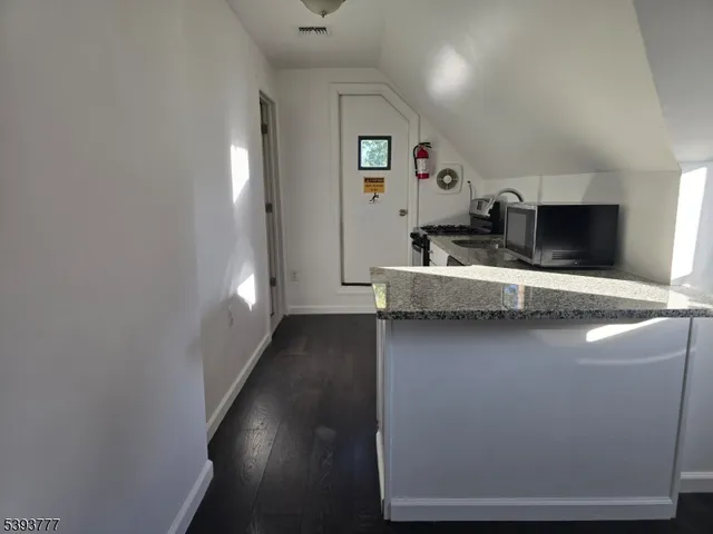 a view of a hallway with wooden floor and a fireplace
