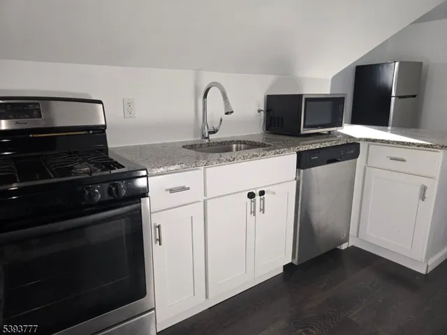 a kitchen with stainless steel appliances granite countertop a stove and a microwave