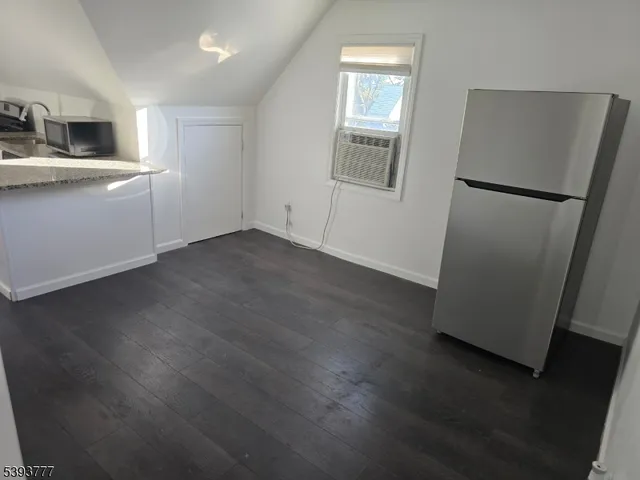 a view of a kitchen with wooden floor and electronic appliances