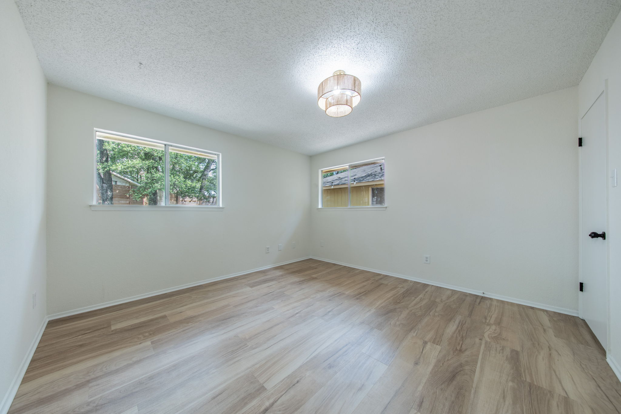 4504 Langtry Lane Austin, TX 78749 - Photo 21 of 24 A quiet bedroom featuring elegant wood flooring and a modern ceiling light fixture.