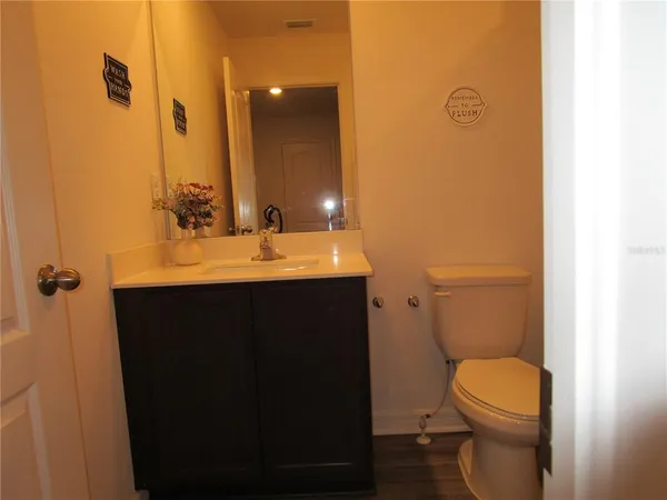 a bathroom with a sink vanity mirror and toilet