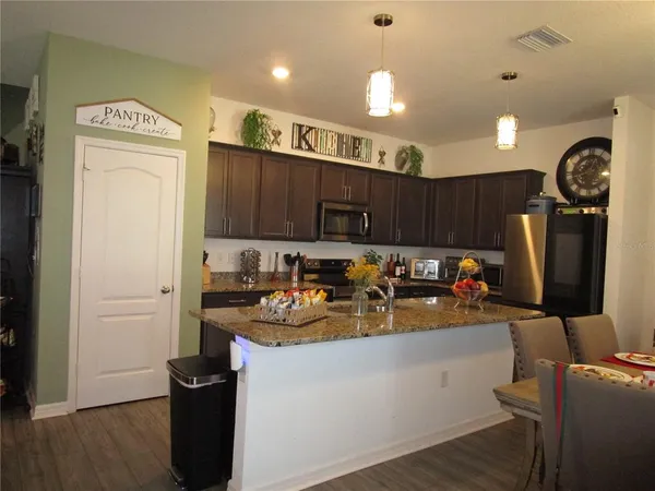 a kitchen with sink refrigerator and cabinets