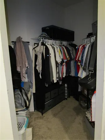 a view of walk in closet with clothes and shoes