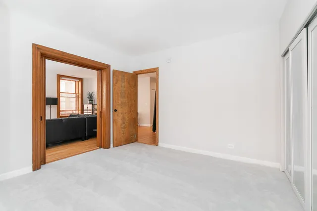 a view of a bedroom with a large bed and two large window