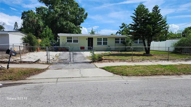 a view of a yard with of house and a tree