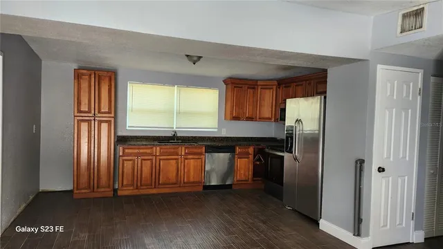 a kitchen with stainless steel appliances granite countertop a refrigerator and a sink