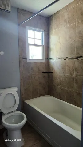 a bathroom with a toilet and a bathtub