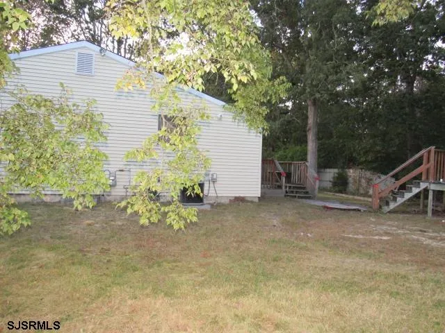 a view of a house with a backyard and tree