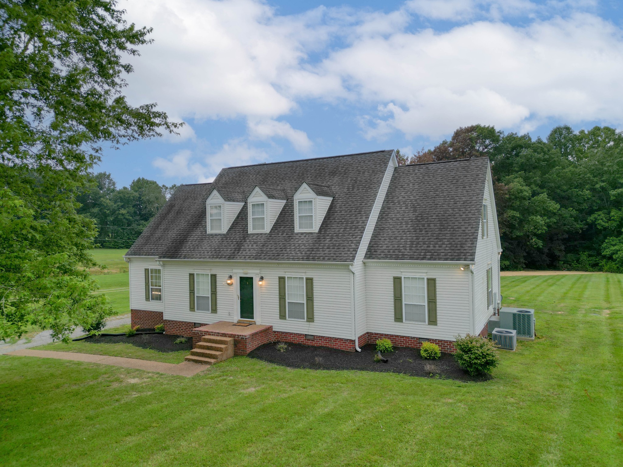 a front view of a house with a garden and yard