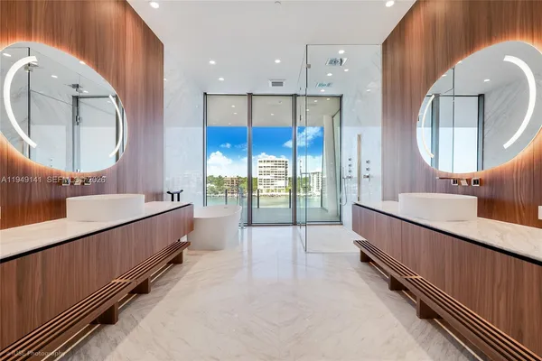 a bathroom with a double vanity sink mirror and bathtub
