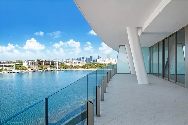 a view of a balcony with dining table & chairs