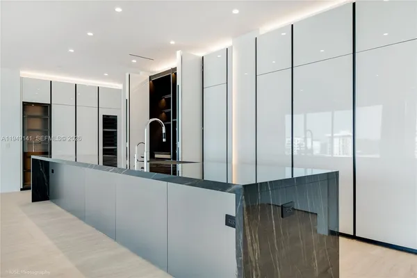a kitchen with stainless steel appliances kitchen island granite countertop a refrigerator and a sink