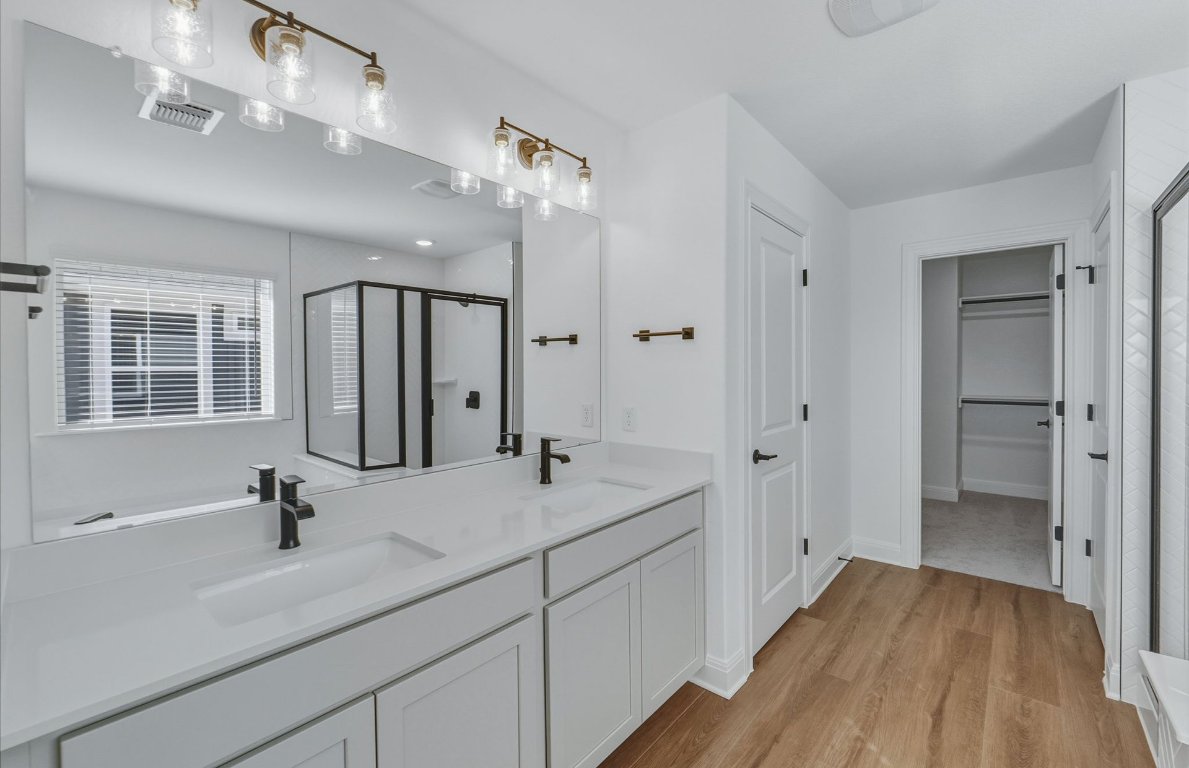 213 Regatta Trail Leander, TX 78641 - Photo 12 of 26 a spacious bathroom with a double vanity sink a mirror and shower
