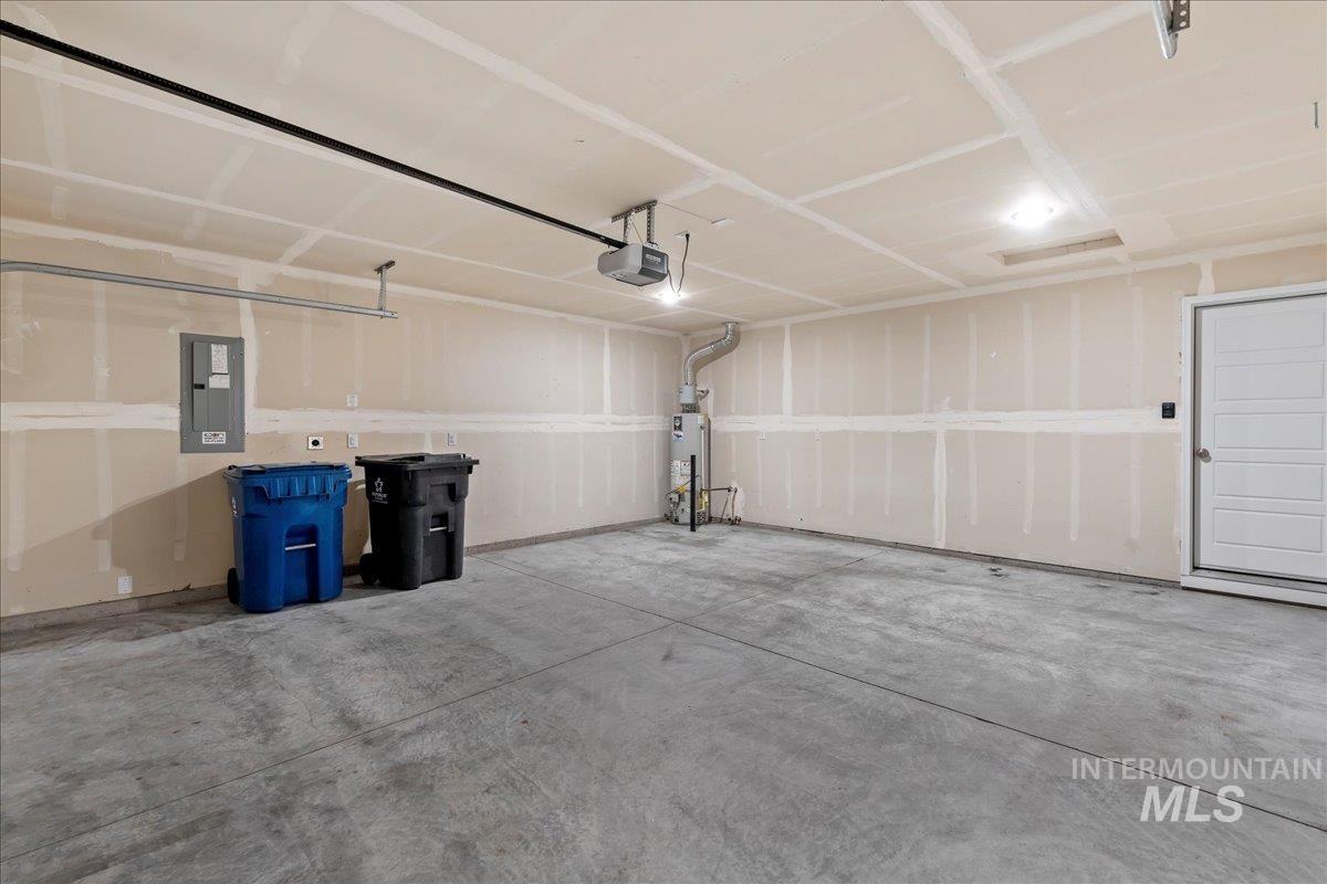 3085 S Green Boise, ID 83709 - Photo 27 of 32 Garage with electric panel, water heater, and a garage door opener