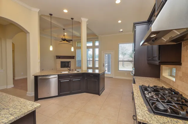 a large kitchen with stainless steel appliances granite countertop a stove and a sink