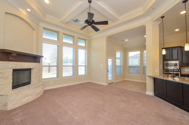 a view of an empty room with a fireplace and a window