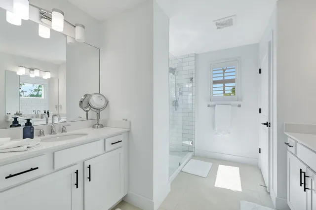 a bathroom with a double vanity sink mirror and shower