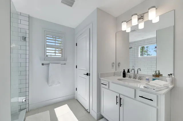 a bathroom with a sink a mirror a vanity and a shower
