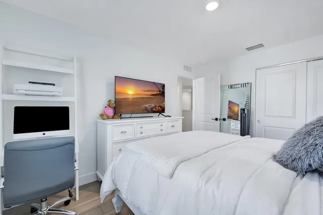 a bedroom with a flat screen television and a bed