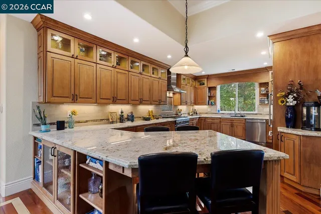 a kitchen with stainless steel appliances granite countertop a stove a refrigerator a sink and a counter