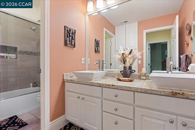 a bathroom with a granite countertop sink mirror and shower