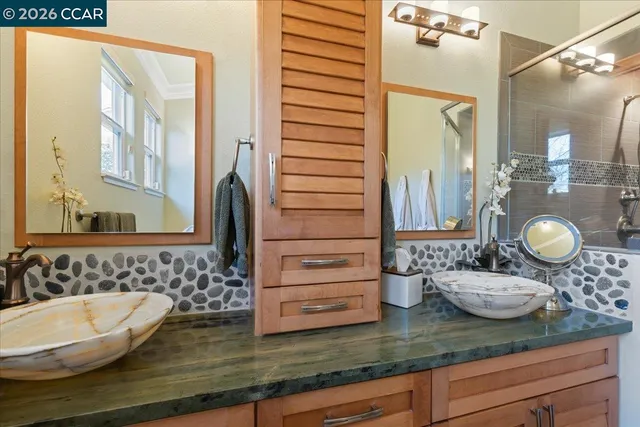 a bathroom with a granite countertop sink and a mirror