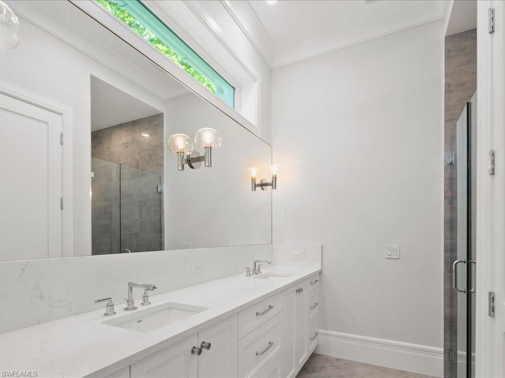 292 Bahia Point Naples, FL 34103 - Photo 23 of 50 a bathroom with a double vanity sink and a mirror