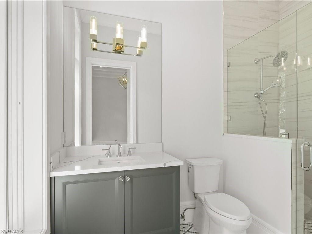 292 Bahia Point Naples, FL 34103 - Photo 25 of 50 a bathroom with a granite countertop sink a toilet and a mirror