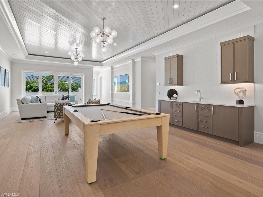 292 Bahia Point Naples, FL 34103 - Photo 29 of 50 a living room with kitchen island furniture and a chandelier