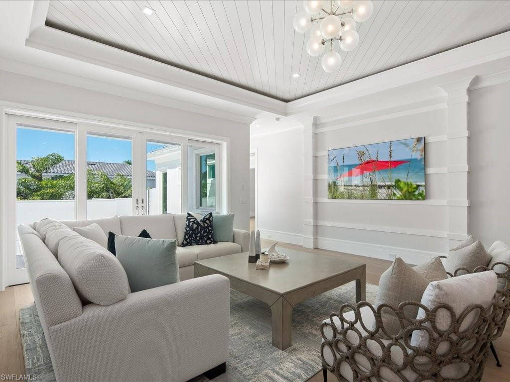 292 Bahia Point Naples, FL 34103 - Photo 30 of 50 a living room with furniture a chandelier and a large window