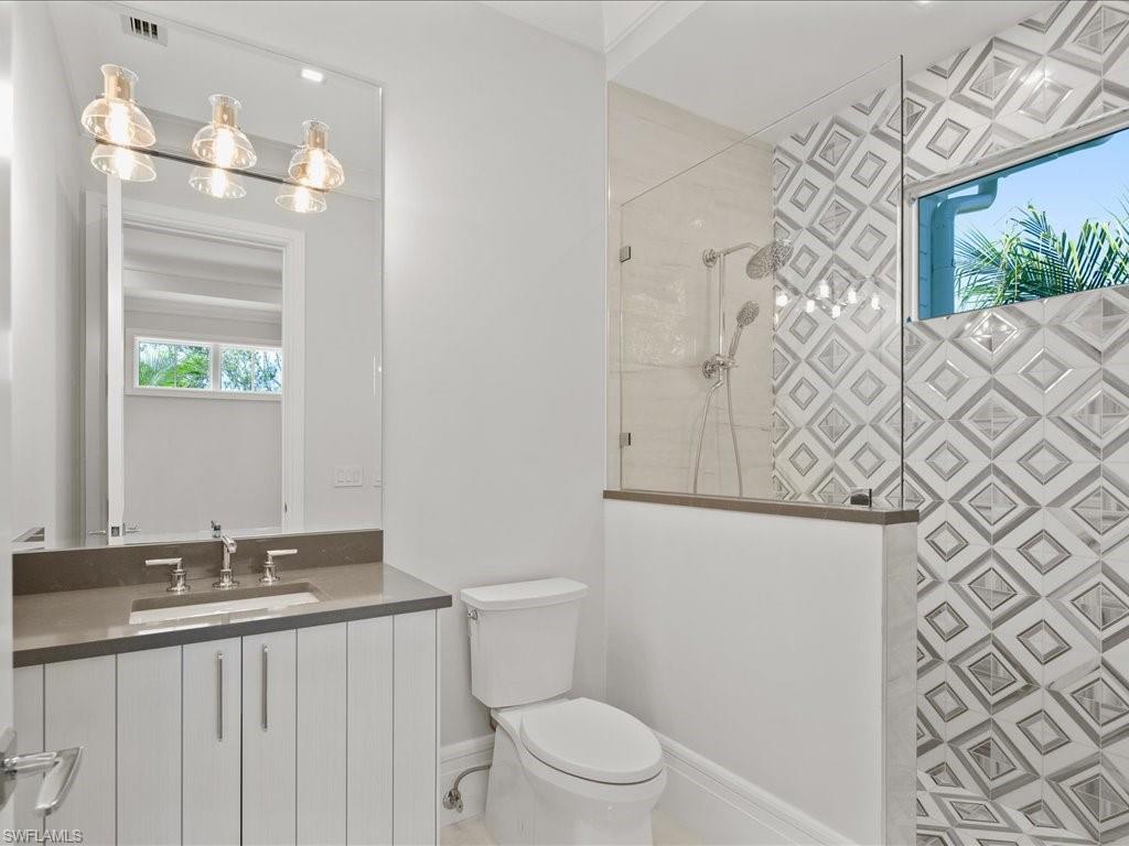 292 Bahia Point Naples, FL 34103 - Photo 32 of 50 a bathroom with a granite countertop sink a toilet and a mirror